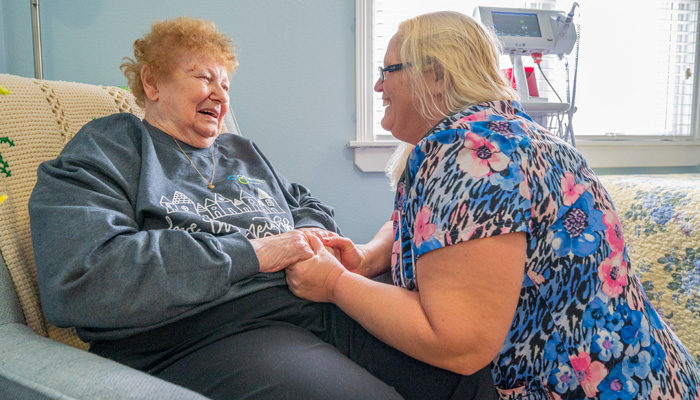 Otterbein nurse holding the hands of an Otterbein resident in skilled nursing.