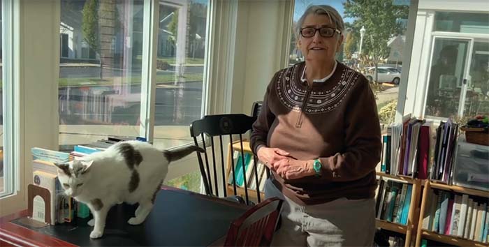 Otterbein Granville resident and her cat together in the the sunroom she uses as a den to do office work.