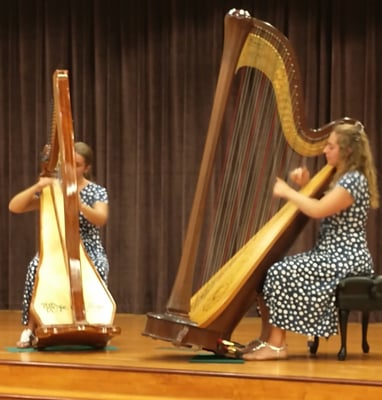 Both Claggett sisters playing a harp