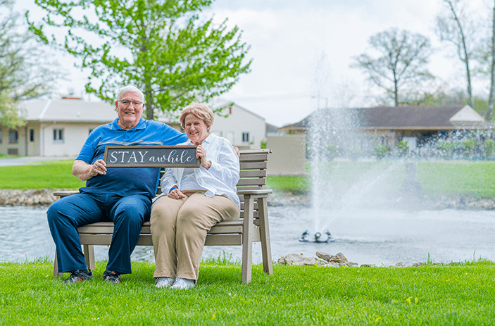 Otterbein St. Marys residents sitting on a bench out by a pond