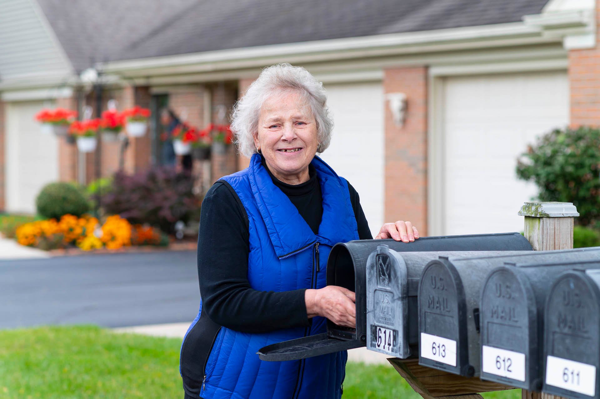 Otterbein Pemberville  resident, Barb Z., reaching in her mailbox and smiling.
