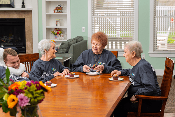 Otterbein SeniorLife Neighborhood elders sitting together enjoying cupcakes.