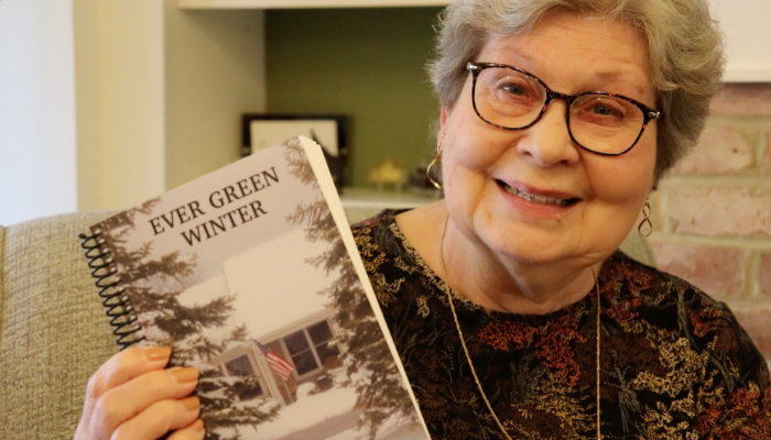 Nancy from the Scribblers at Otterbein Lebanon holding a copy of Ever Green Winter by the Scribblers