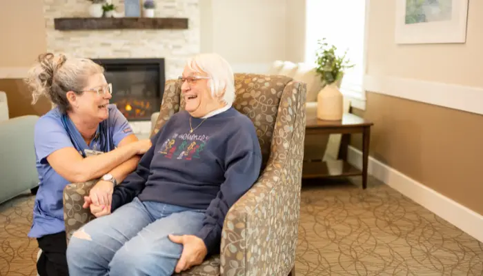 Assisted living resident laughs with nurse