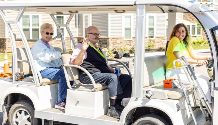 Otterbein Pemberville assisted living residents riding around on a golf-cart on campus.