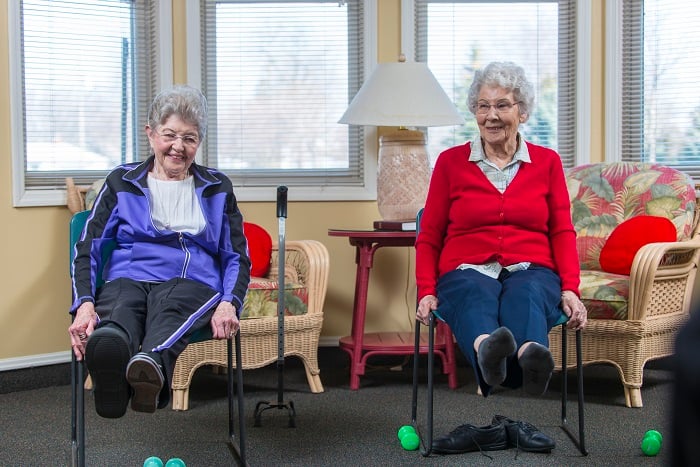 Two senior women do chair exercises